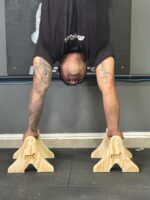 Atleta treinando flexão com paralela de chão Parallette M1 Fitness