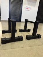 Detalhe da base em T e pés antiderrapantes da paralela de chão 25cm M1 Fitness