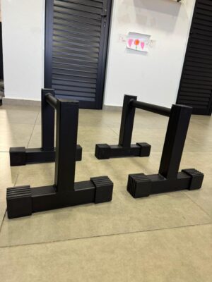 Detalhe da base em T e pés antiderrapantes da paralela de chão 25cm M1 Fitness
