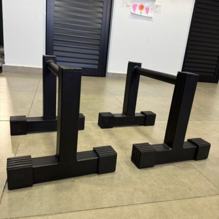 Detalhe da base em T e pés antiderrapantes da paralela de chão 25cm M1 Fitness